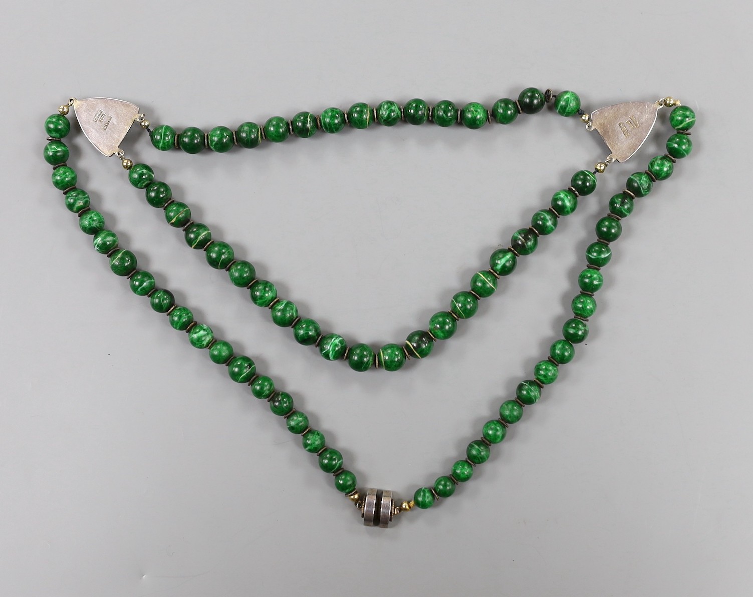 A 20th century Chinese single/double strand malachite bead necklace, with white metal clasp and triangular motifs, stamped 'China Liu Silver', 67cm.